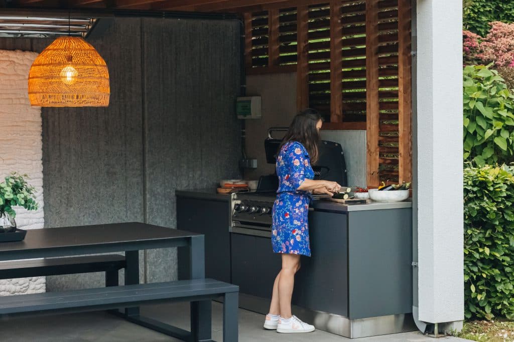Femme découpant ses légumes sur le plan de travail de sa cuisine extérieure Outdoor Passion