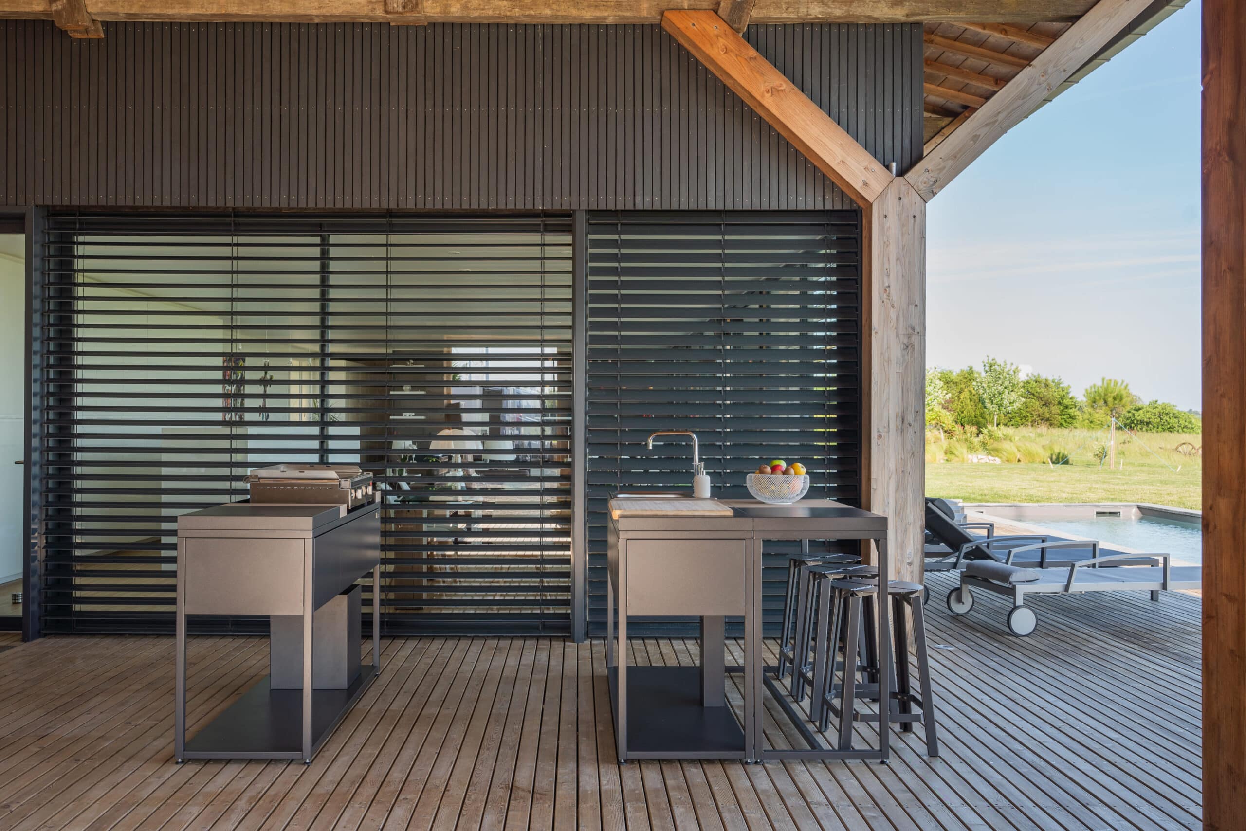 Deux modules de cuisine d'extérieur Soleil Carré positionnés parallèlement sur une terrasse sous véranda. Disponible chez Inox Passion